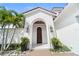 Stunning close-up of the arched front doorway with a solid wood door and elegant lighting at 9743 Covent Garden Dr, Orlando, FL 32827