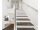 Modern staircase with glass railing and wood treads lead to the second floor at 9743 Covent Garden Dr, Orlando, FL 32827