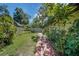 A serene brick lined path through a lush backyard, perfect for enjoying the outdoors at 102 Ichabod Trl, Longwood, FL 32750
