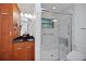 Modern bathroom featuring glass shower with a marble-like surround and cherry wood vanity at 102 Ichabod Trl, Longwood, FL 32750