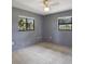 Neutral bedroom featuring two windows, neutral carpet, gray walls, and ceiling fan at 102 Ichabod Trl, Longwood, FL 32750