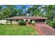 Charming single-story home boasts a well-manicured lawn and inviting curb appeal with lush landscaping at 102 Ichabod Trl, Longwood, FL 32750