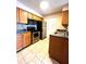 Eat-in kitchen features stainless steel appliances, wood cabinets, and tiled floor at 1057 S Hiawassee Rd # 1913, Orlando, FL 32835