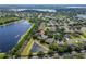 Aerial view of the single-story home with screened in lanai, pond and lake view in community at 13108 Lakeshore Grove Dr, Winter Garden, FL 34787