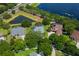 Aerial view of the single-story home with screened in lanai, well-manicured lawn and pond view at 13108 Lakeshore Grove Dr, Winter Garden, FL 34787
