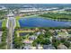 Aerial view of the single-story home with screened in lanai, pond and lake view in community at 13108 Lakeshore Grove Dr, Winter Garden, FL 34787