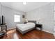 Bright bedroom featuring hardwood floors, a decorative accent wall, and a comfortable queen-size bed at 13108 Lakeshore Grove Dr, Winter Garden, FL 34787