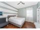 This is a bedroom with hardwood floors, grey and white striped walls, and a ceiling fan at 13108 Lakeshore Grove Dr, Winter Garden, FL 34787