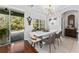 Elegant dining area with modern lighting, contemporary art, and sliding door access to the pool at 13108 Lakeshore Grove Dr, Winter Garden, FL 34787