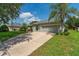 Single-story home featuring a well-manicured lawn, beautiful landscaping, and a two-car garage at 13108 Lakeshore Grove Dr, Winter Garden, FL 34787