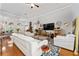 A spacious living room with hardwood floors, white leather sofas, and access to other rooms at 13108 Lakeshore Grove Dr, Winter Garden, FL 34787