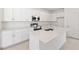 Bright kitchen featuring a central island, white cabinets, and stainless steel appliances at 150 Fredericksburg Ave, Orange City, FL 32763