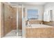 Bathroom features large soaking tub with shower, and bright window at 15058 Sawgrass Bluff Dr, Winter Garden, FL 34787