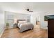 Bright bedroom features wood floors, ceiling fan and ensuite bathroom with large garden tub at 15058 Sawgrass Bluff Dr, Winter Garden, FL 34787