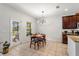 Cozy dining area with natural light, modern light fixture, and easy access to the outdoor patio at 15058 Sawgrass Bluff Dr, Winter Garden, FL 34787