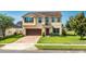 Charming two-story home with a well-manicured lawn and a brick driveway leading to an attached two-car garage at 15058 Sawgrass Bluff Dr, Winter Garden, FL 34787