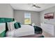 Cozy bedroom with green headboard, modern dresser, and a flat-screen television at 1533 Flange Dr, Davenport, FL 33896