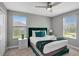 Bedroom with a plush green headboard, large windows, and stylish bedside tables at 1533 Flange Dr, Davenport, FL 33896