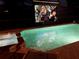 Pool and hot tub with an outdoor projector showing a movie for nighttime entertainment at 1533 Flange Dr, Davenport, FL 33896
