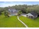 Aerial view of the property with manicured lawns, a sparkling pool, and mature landscaping at 1550 Bluewater Run, Chuluota, FL 32766
