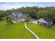 Aerial view of a large property with a pool, detached garage, and lush landscaping at 1550 Bluewater Run, Chuluota, FL 32766