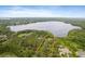 An aerial view showcases a large property with lush landscaping and lake access at 1550 Bluewater Run, Chuluota, FL 32766