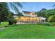 A spacious backyard with lush green grass, mature trees, and a black fence enclosing a beautiful pool area at 1550 Bluewater Run, Chuluota, FL 32766