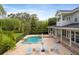 Lovely backyard with a pool, patio with lounge chairs, and mature landscaping, creating a serene outdoor space at 1550 Bluewater Run, Chuluota, FL 32766