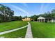 Expansive backyard featuring a long stone pathway leading to the house and a detached garage with ample space at 1550 Bluewater Run, Chuluota, FL 32766