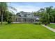 Expansive backyard with a pool, patio, lush lawn, and mature trees, creating a private outdoor oasis at 1550 Bluewater Run, Chuluota, FL 32766