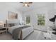 Sunlit bedroom with a bed, stylish desk and bright windows overlooking a garden at 1550 Bluewater Run, Chuluota, FL 32766