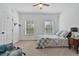 Bright bedroom with two windows, neutral tones, ceiling fan, and a comfy reading chair at 1550 Bluewater Run, Chuluota, FL 32766