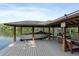Waterfront boat dock featuring a boat lift and covered seating area for lakeside relaxation at 1550 Bluewater Run, Chuluota, FL 32766