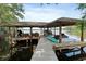 Covered boat dock on the lake with seating area, boat lift, and jet ski parking at 1550 Bluewater Run, Chuluota, FL 32766