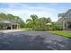 Long driveway leading to a detached garage and carport, surrounded by lush landscaping and mature trees at 1550 Bluewater Run, Chuluota, FL 32766
