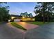 Stunning two-story home featuring a brick driveway, an attached garage, and a charming wraparound porch at 1550 Bluewater Run, Chuluota, FL 32766