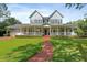 Charming two-story home with a welcoming front porch, brick pathway, and manicured lawn at 1550 Bluewater Run, Chuluota, FL 32766