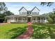 Charming two-story home boasts a large front porch, green lawn, and beautiful curb appeal at 1550 Bluewater Run, Chuluota, FL 32766