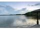 Scenic lake view from a wooden dock, showcasing the calm water and distant shoreline under a cloudy sky at 1550 Bluewater Run, Chuluota, FL 32766
