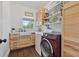 Functional laundry room with modern washer and dryer, along with built-in cabinets and a utility sink at 1550 Bluewater Run, Chuluota, FL 32766