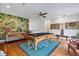 Inviting living room featuring a pool table, vibrant mural, and stylish decor at 1550 Bluewater Run, Chuluota, FL 32766