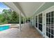 Spacious covered patio with brick flooring, pool access, and outdoor seating, perfect for entertaining at 1550 Bluewater Run, Chuluota, FL 32766