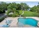 Aerial view of a backyard oasis featuring a stone-lined pool, spa, and lush tropical landscaping at 1550 Bluewater Run, Chuluota, FL 32766