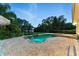 Inviting backyard pool with a stone patio, waterfall feature, and a spa, perfect for relaxation and entertaining at 1550 Bluewater Run, Chuluota, FL 32766