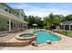 An inviting pool and hot tub with a backdrop of lush landscaping and a covered patio at 1550 Bluewater Run, Chuluota, FL 32766