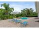Relaxing outdoor pool area with lounge chairs, umbrella and manicured landscaping at 1550 Bluewater Run, Chuluota, FL 32766