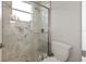 Bright bathroom with marble tile shower, window, and standard toilet at 2046 Westover Reserve Blvd, Windermere, FL 34786