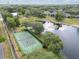 Aerial shot of community tennis courts near a pond surrounded by lush greenery at 2046 Westover Reserve Blvd, Windermere, FL 34786