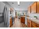 An open kitchen has stainless steel appliances, wood cabinets and floors, and a view into the dining area at 210 Coleton Lane, Deland, FL 32724
