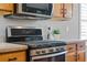 A kitchen features stainless steel appliances, modern countertops, and wood cabinets with black hardware at 210 Coleton Lane, Deland, FL 32724